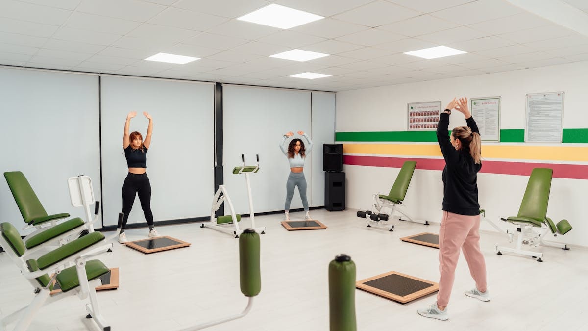 Three women engage in a workout session in a brightly lit, modern fitness studio in Yalova, Türkiye.